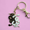 Gold keychain with black and white enamel snakes tangled together