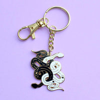 Gold keychain with black and white enamel snakes tangled together