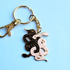 Gold keychain with black and white enamel snakes tangled together